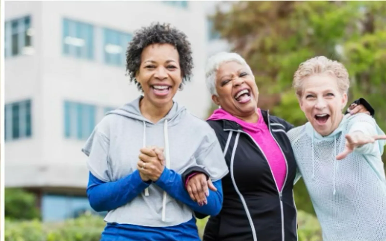 Three women laughing together outdoors